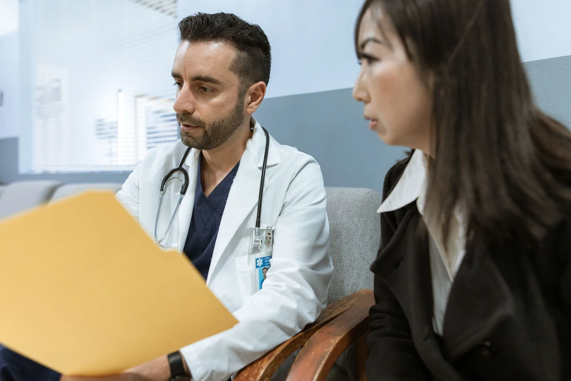 A physician talking with a patient across a desk during a consultation